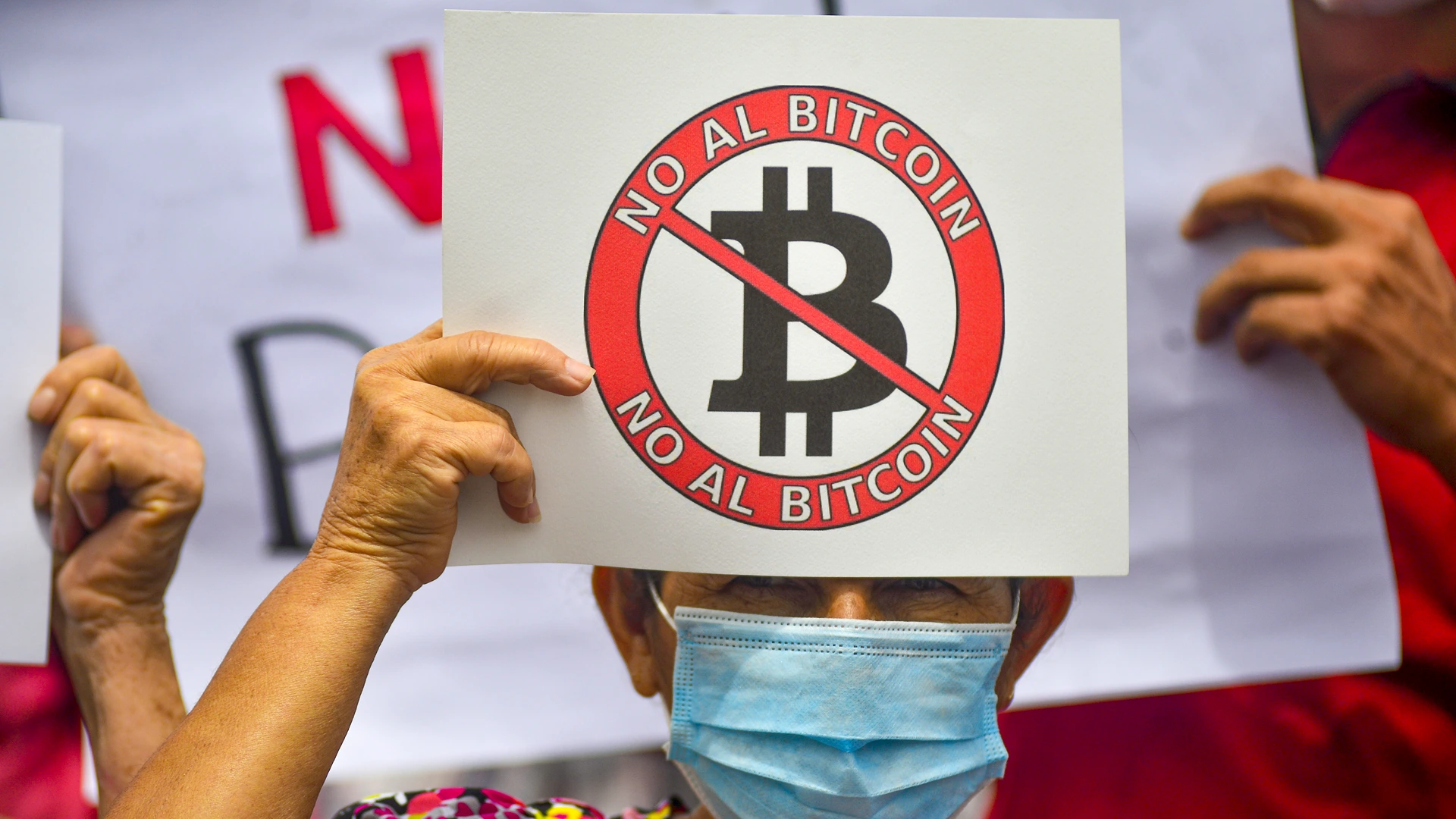 El Salvador Protestor holding No Bitcoin sign.